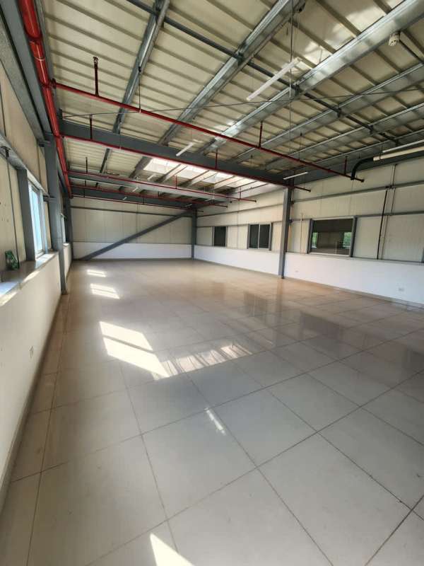 Empty warehouse with large rolling shutter door, skylight, high roof for rent Tocumen area Panama