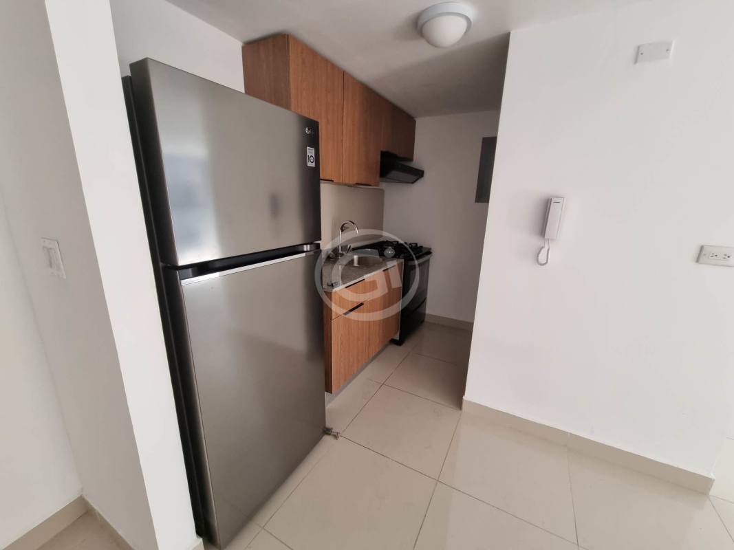 Minimalist kitchen with refrigerator, stove and wood cabinets at PH Worldwide Plaza Via España