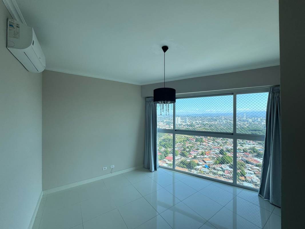 Bright bedroom with city views, safety mesh windows, and tile flooring PH Nautica Panama