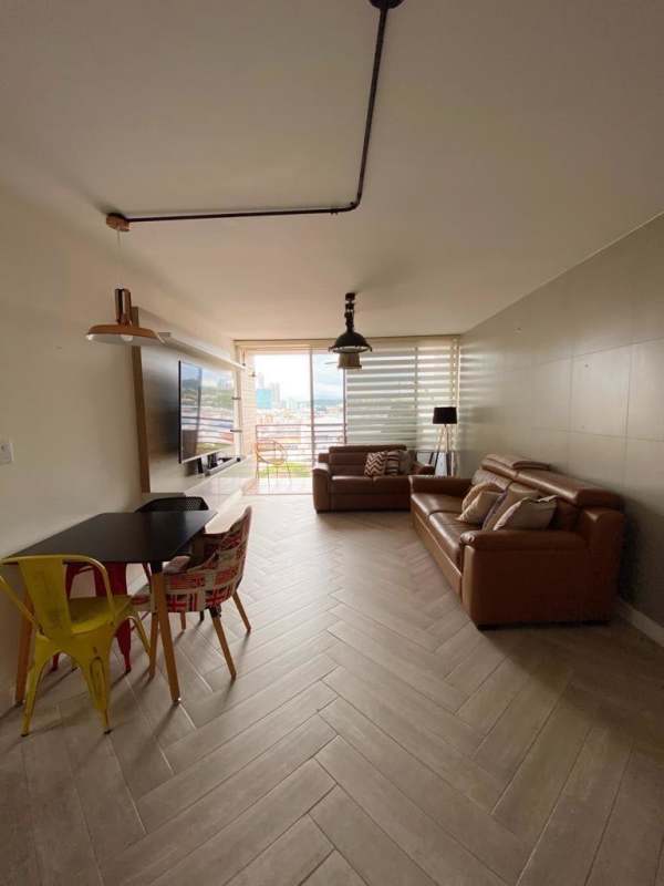 Living room area with balcony access, floor tile design and city skyline view PH El Carmen Panama