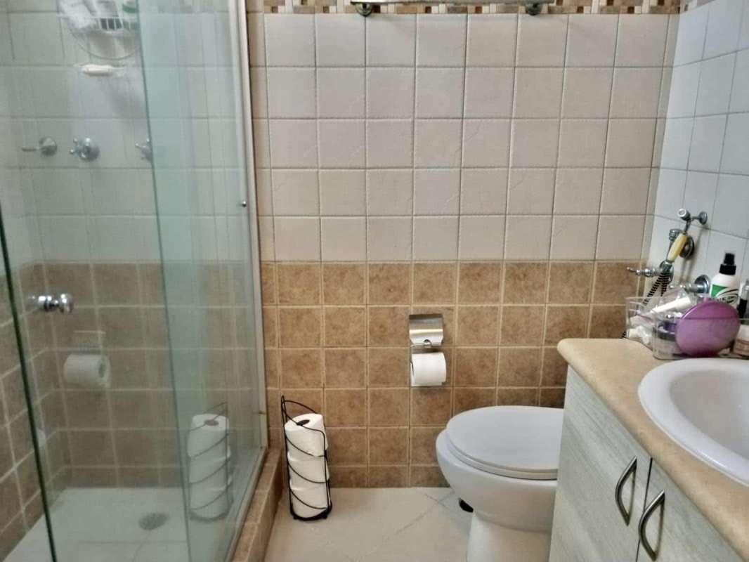 Contemporary bathroom with glass shower, vanity sink, tiled walls and modern fixtures in PH El Cangrejo Central Panama City