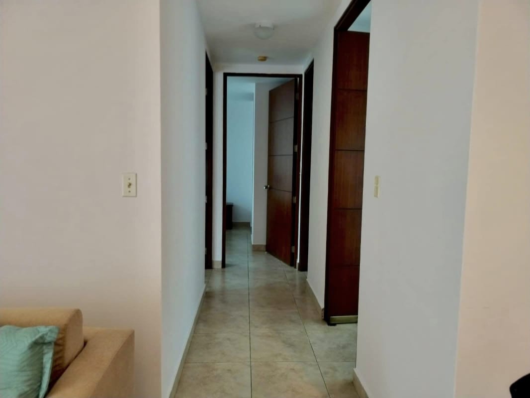 Interior hallway with ceramic tile and neutral walls leading to bedrooms in PH El Cangrejo Central Panama City