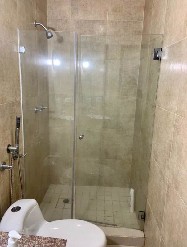 Private bathroom with glass-enclosed shower inside furnished rental room at PH BICSA Avenida Balboa