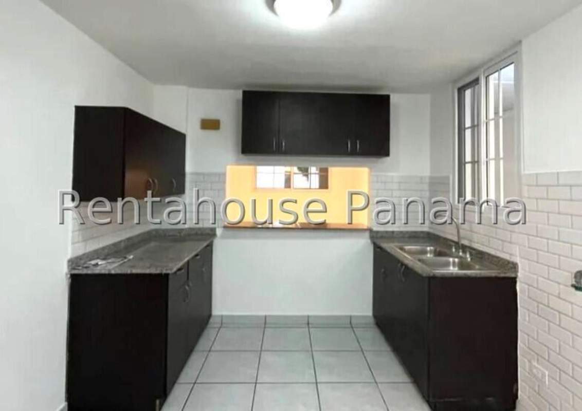 Covered outdoor terrace with tile flooring, ceiling fans, adjacent green yard Condado del Rey Panama