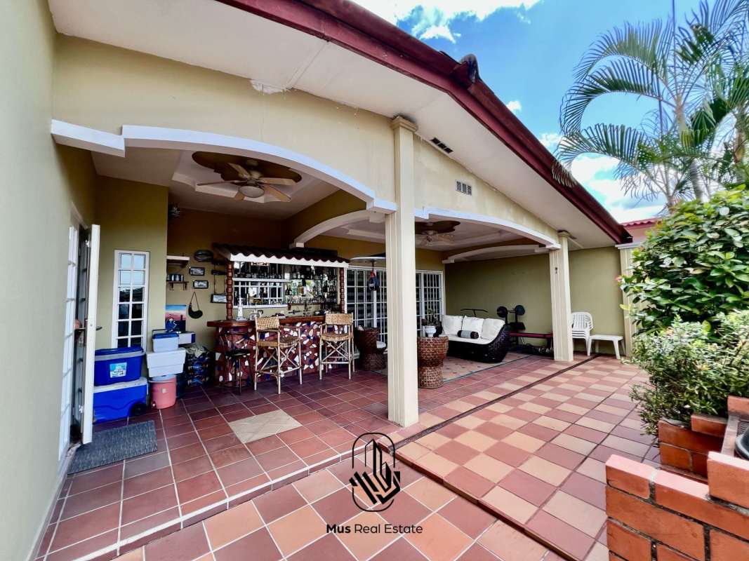 Outdoor patio terrace with bar and ceiling fans at Brisas del Golf home Panama