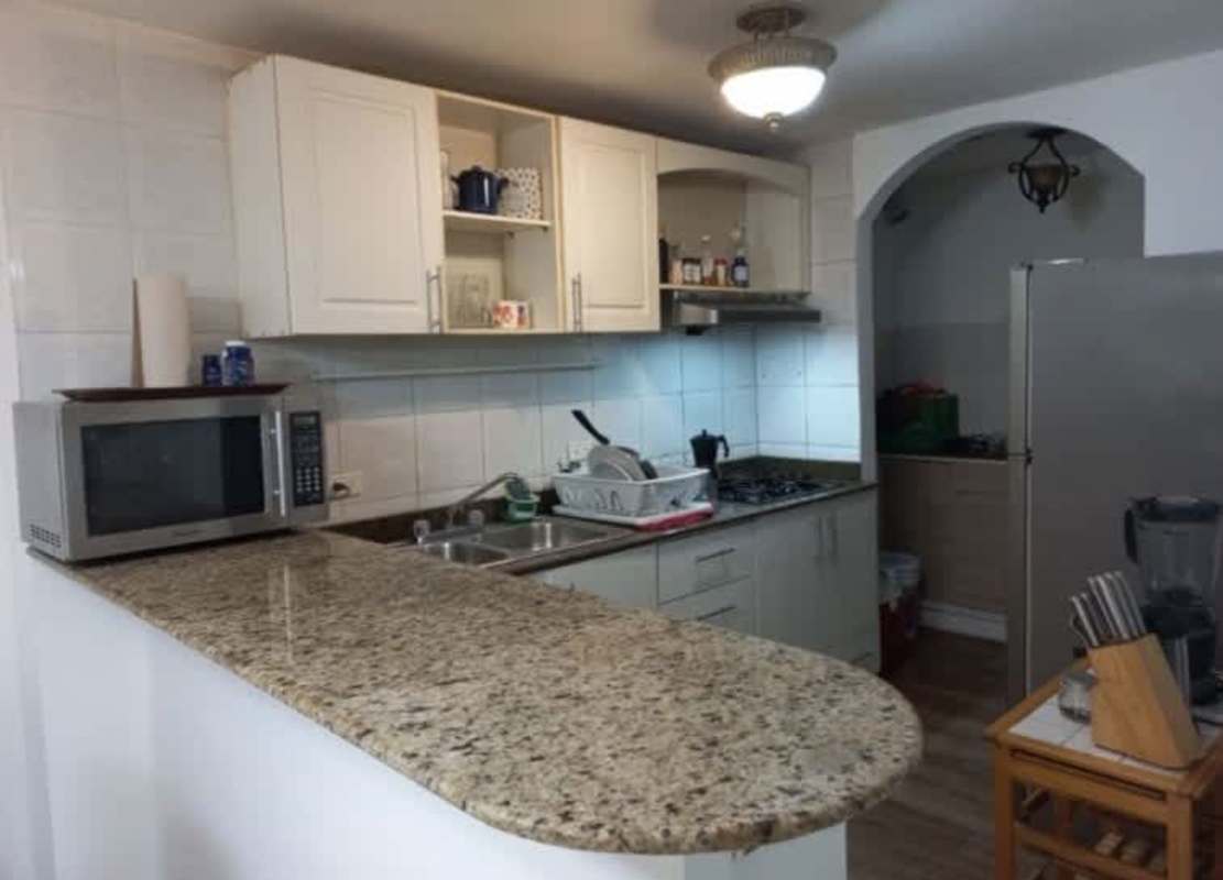 Modern white kitchen with granite counter and gas stove in PH Albrook Gardens Clayton Panama