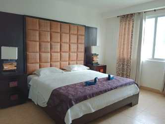 Furnished bedroom with oceanview balcony access at Nikki Residences Playa Blanca Panama