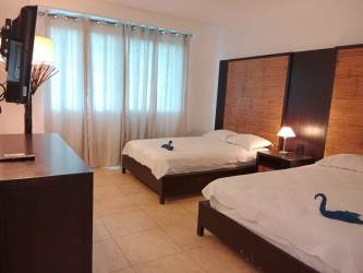 Open concept kitchen island seating with living room in oceanfront condo at Nikki Residences Playa Blanca Panama