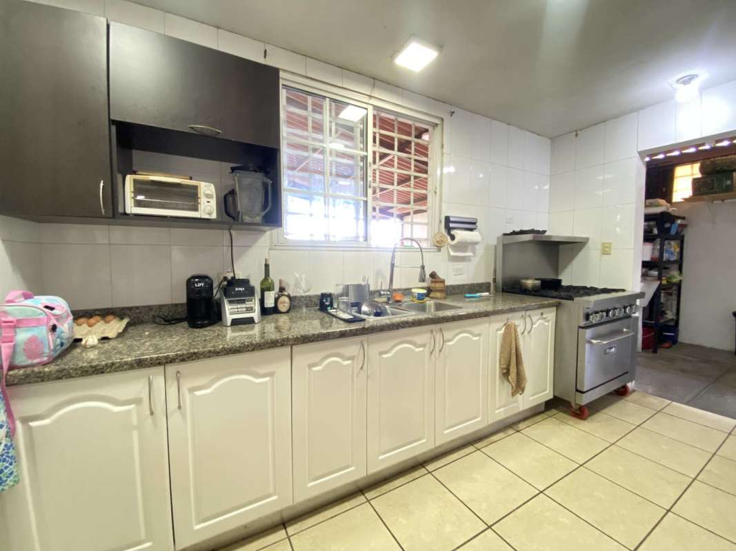 Spacious living and dining area with tile floors and large windows in Brisas del Golf Panama house