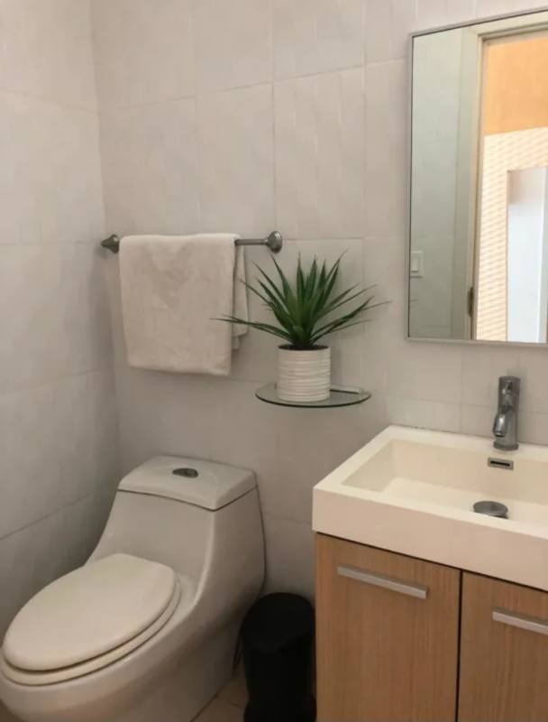 Compact minimalist powder room with vanity mirror PH Oasis Punta Pacifica Panama City