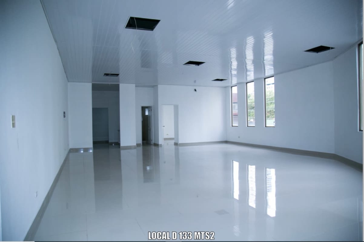 Street view of commercial building facade with glass windows and canopy entrance Panama City