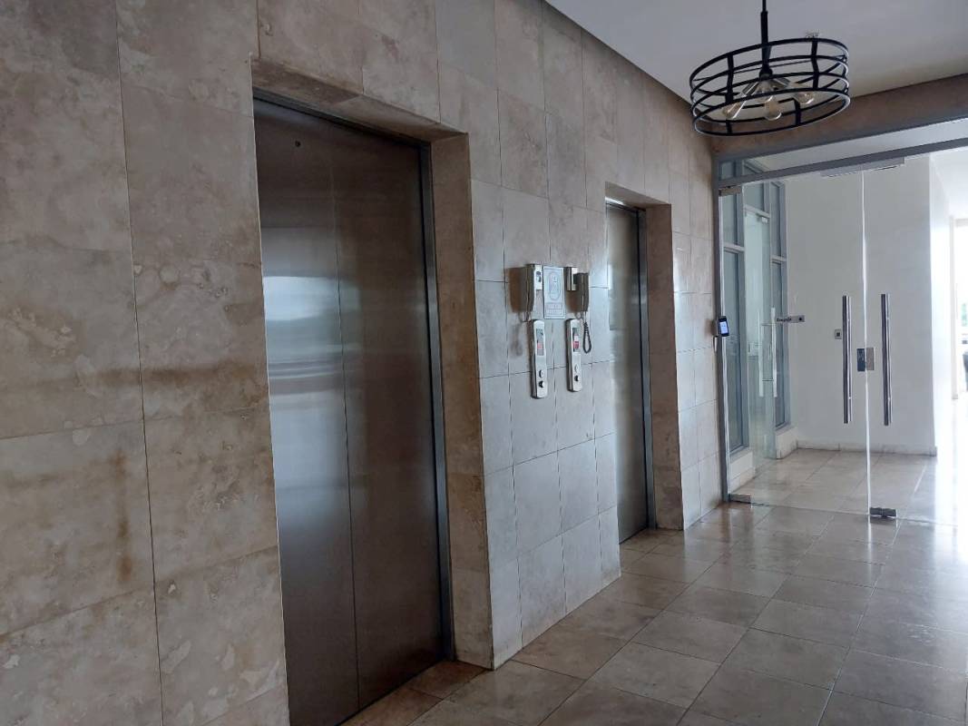 Bright apartment hallway with ceramic floors, doorways to bedrooms PH Rokas Panama