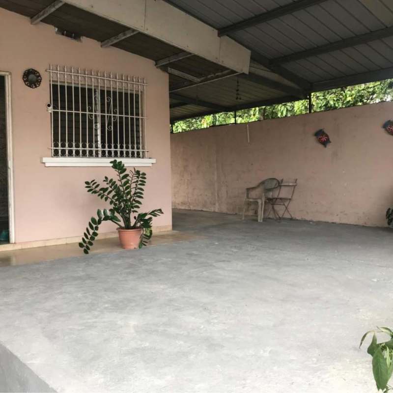 Bedroom with grilled window and bed in Villa Belén Tocumen house for sale