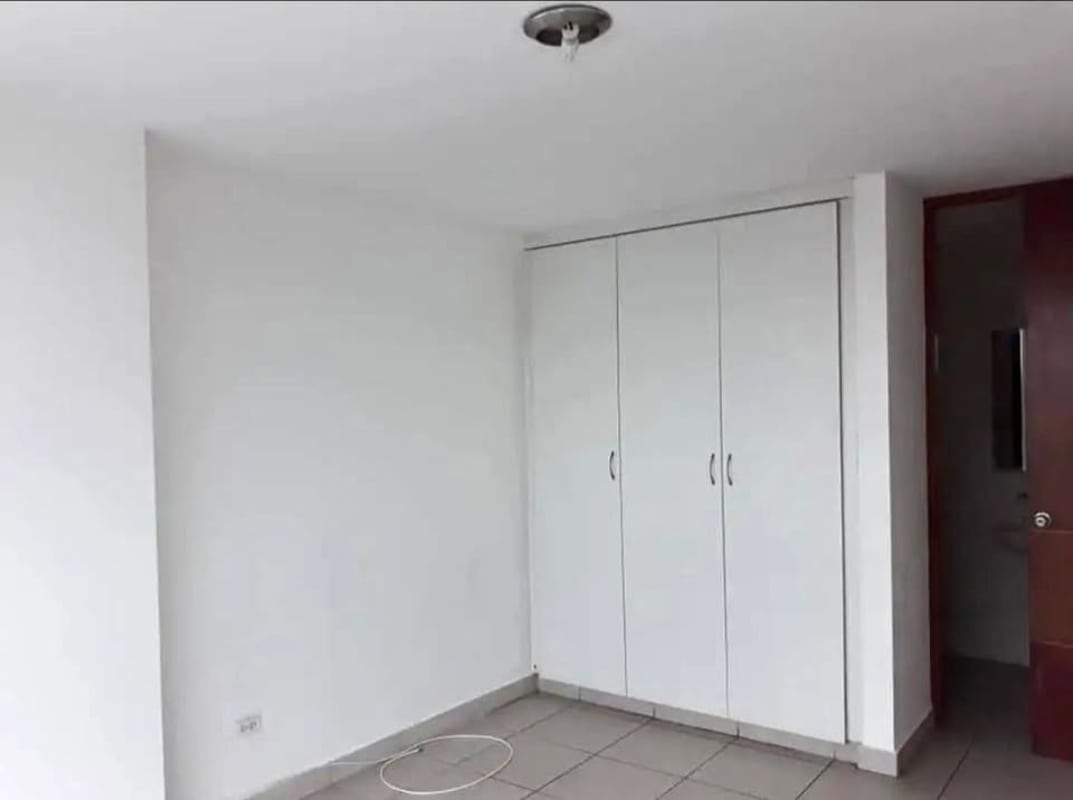 Empty minimalist bedroom with wardrobe and white walls at Central Park Panama City