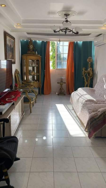 Four-story apartment complex with balconies, AC units, parking lot and palm trees at PH Villas de Costa del Este Panama