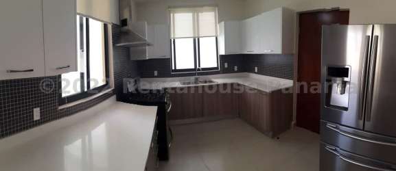 Large open plan living room with windows and tile floors in Panama Pacifico house