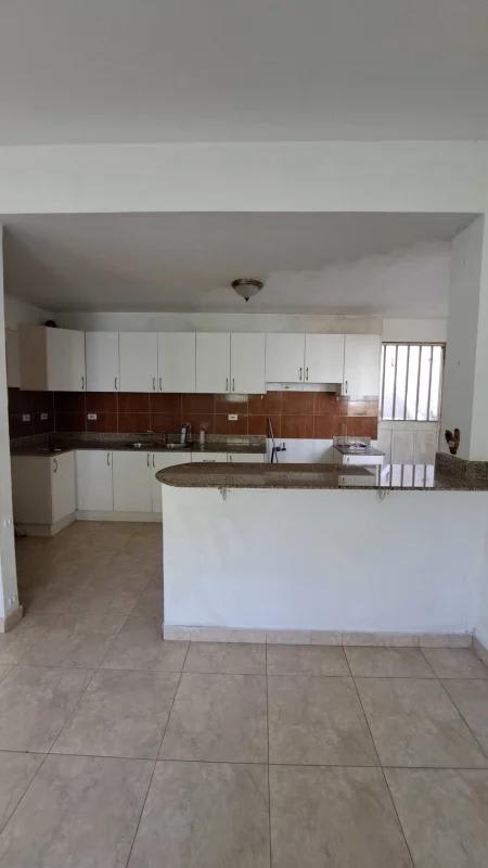 Contemporary kitchen with peninsula island, granite counters, white cabinets in house Altos de Santa María Panama