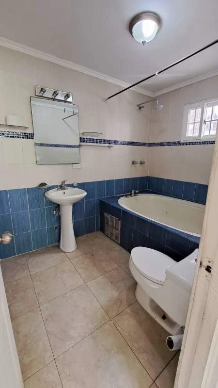 Contemporary bathroom with blue mosaic tile, bathtub, pedestal sink in house Altos de Santa María Panama