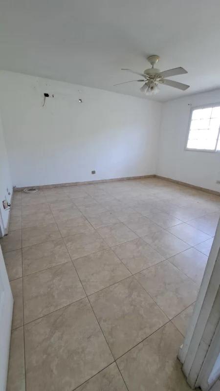 Bedroom featuring ceiling fan, beige tile floor, large windows in Altos de Santa María family house Panama City