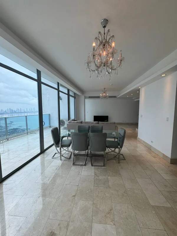 Open living dining area with floor-to-ceiling glass, balcony and ocean view in Grand Tower Panama