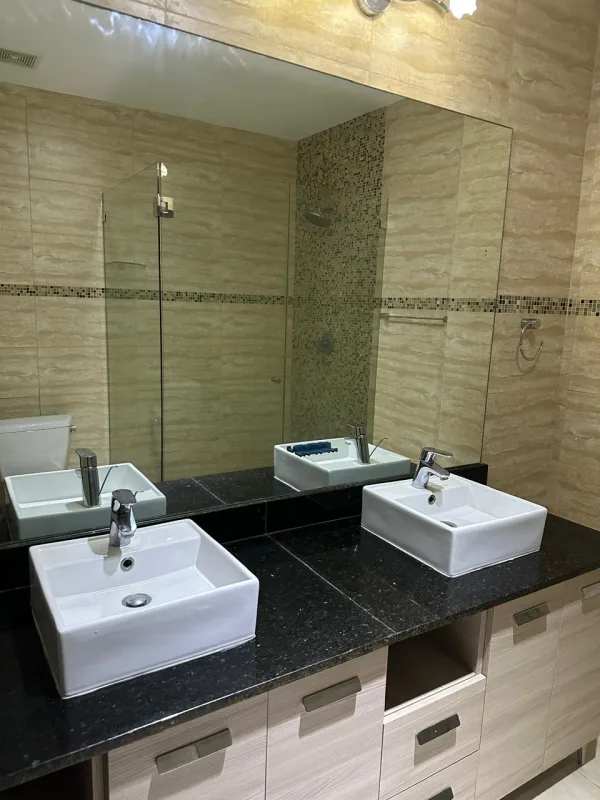 Luxurious bathroom with double vanity and glass shower in PH Grand Tower Punta Pacífica Panama