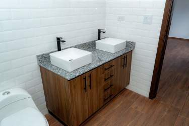 Spacious bedroom or office with wood-look tile flooring and white walls in Alto Boquete house