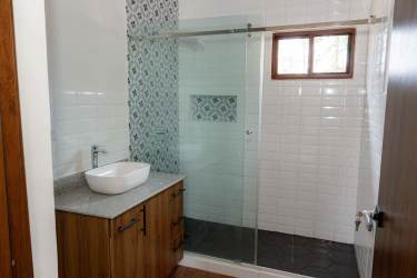 Glass shower modern sink patterned tile accents new construction bathroom Boquete Panama
