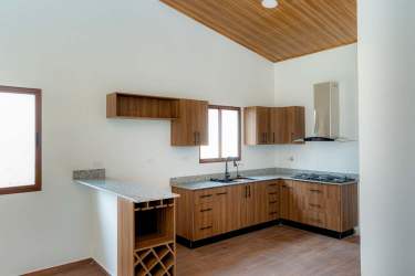 Modern kitchen with granite countertops wood cabinets wine rack Alto Boquete Panama