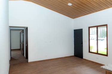 Minimalist bright living area with large windows vaulted ceiling wood floors Alto Boquete