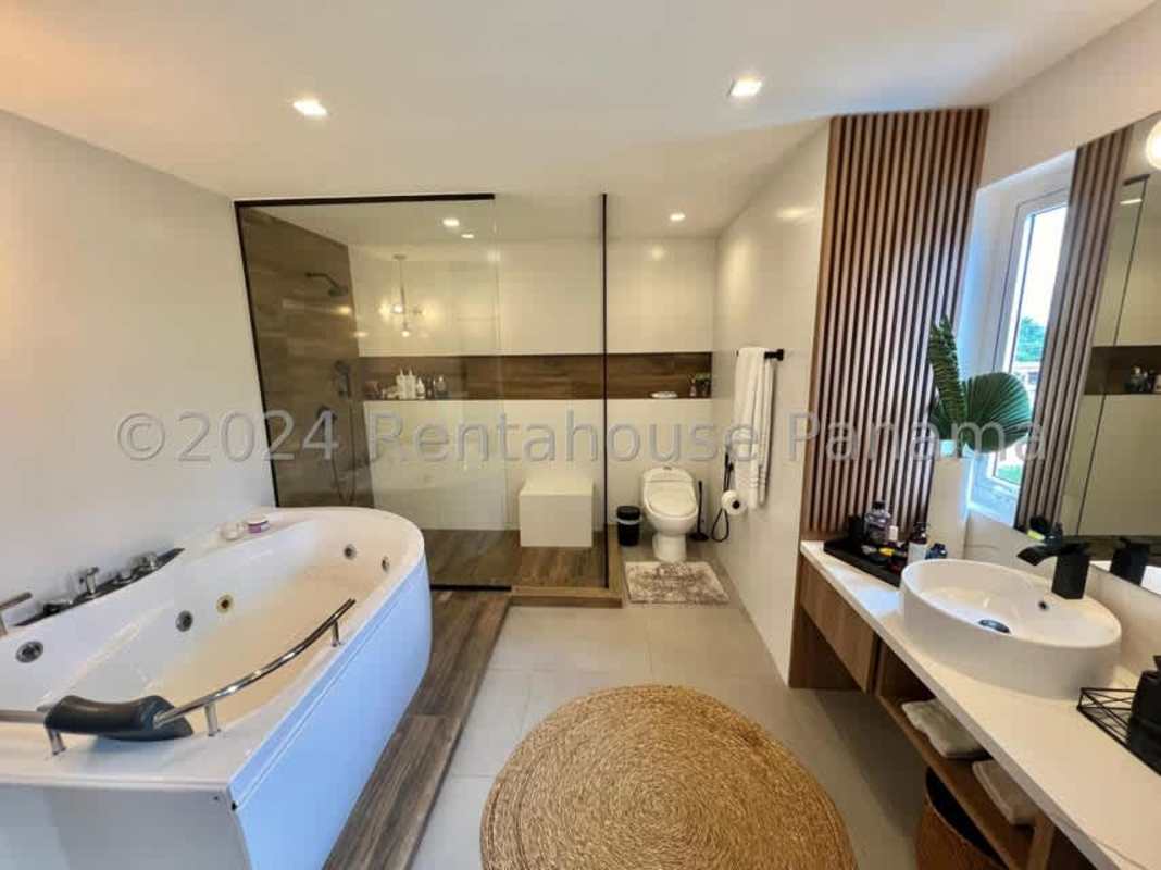 Master bedroom with walk-in closet and balcony view of city skyline Villa Lucre Panama