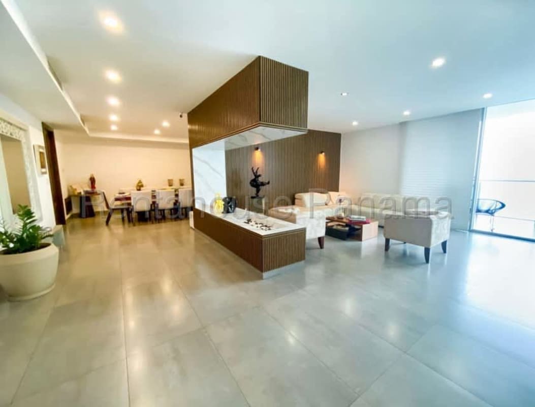 Open concept living dining room with floor-to-ceiling windows ocean and city views in The Ocean Club Punta Pacifica Panama
