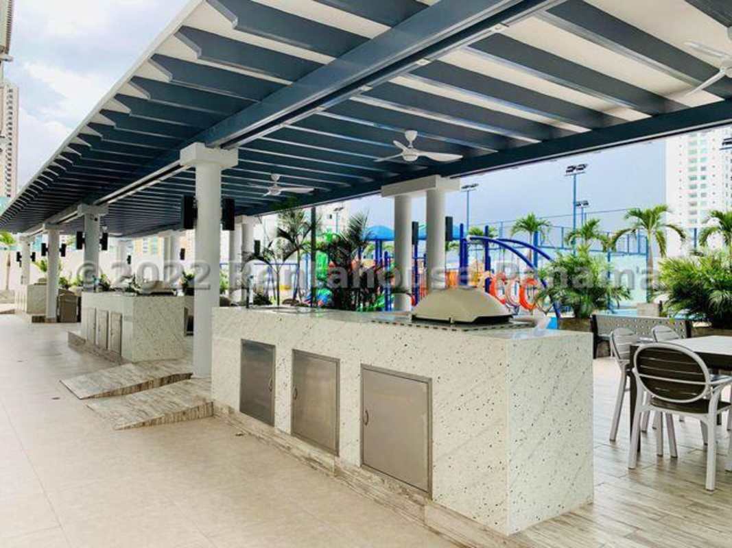 Outdoor BBQ lounge with pergola and adjacent children’s playground in Ten Tower Panama City