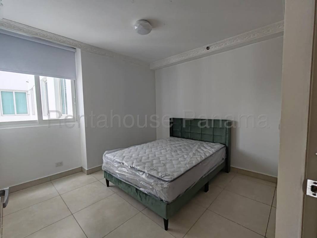 Bright bedroom with green bed, natural light, garden view in Clayton Park II apartment