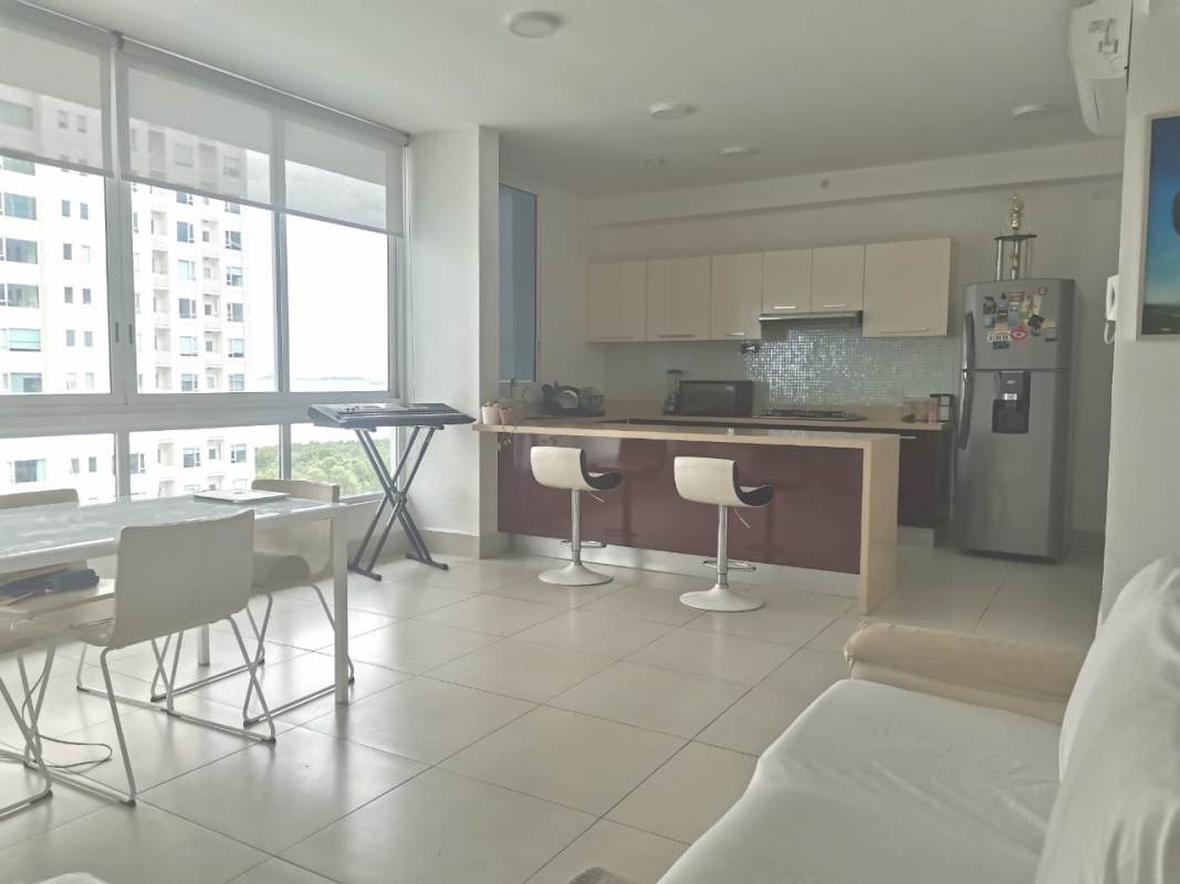 Modern open kitchen with island and dining space, panoramic windows at PH Castellamare Panama