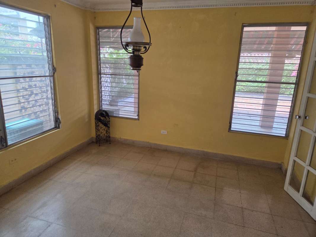 Mid-century style kitchen with wooden cabinets, gas stove and window blinds in La Alameda house for sale Panama City.