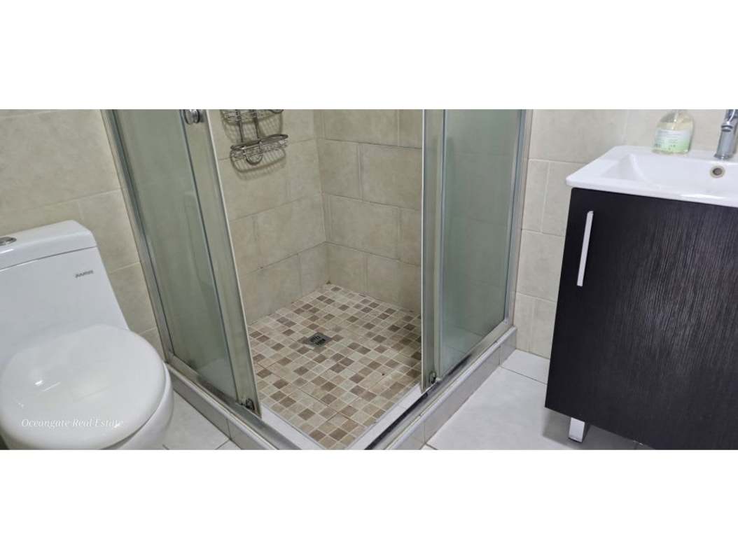 Modern bathroom with glass enclosed shower and vanity in Bay View Tower Panama