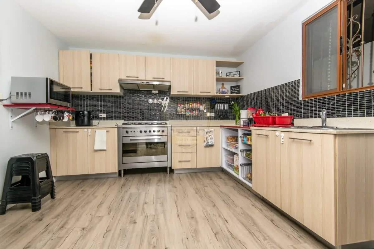 Kitchen with wood cabinetry, appliances, tile floor in family rental house Milla 8 Panama