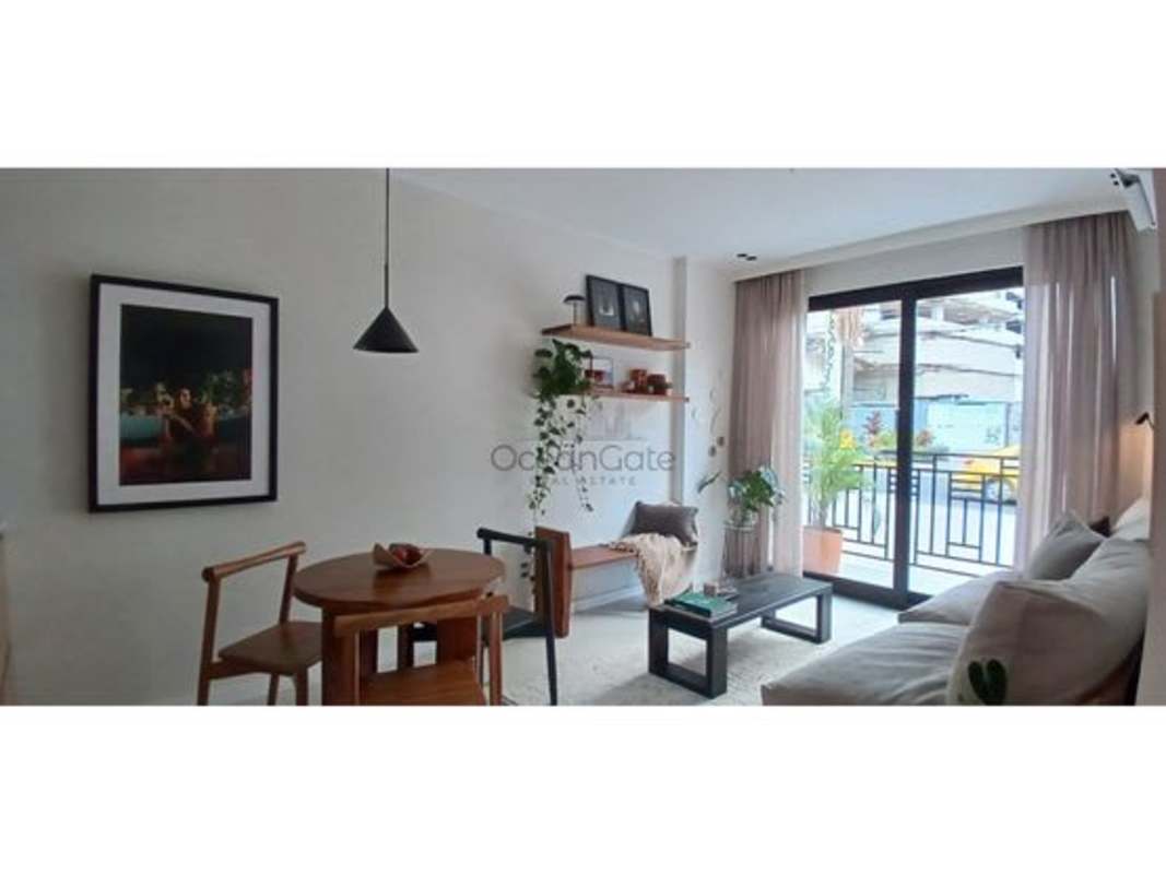 Modern living room with large sliding glass door to balcony in PH Amara Panama City.