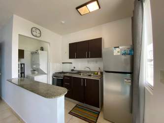 Contemporary kitchen in furnished apartment with granite countertops, tile backsplash, stove and fridge Playa Dorada Vacamonte Panama