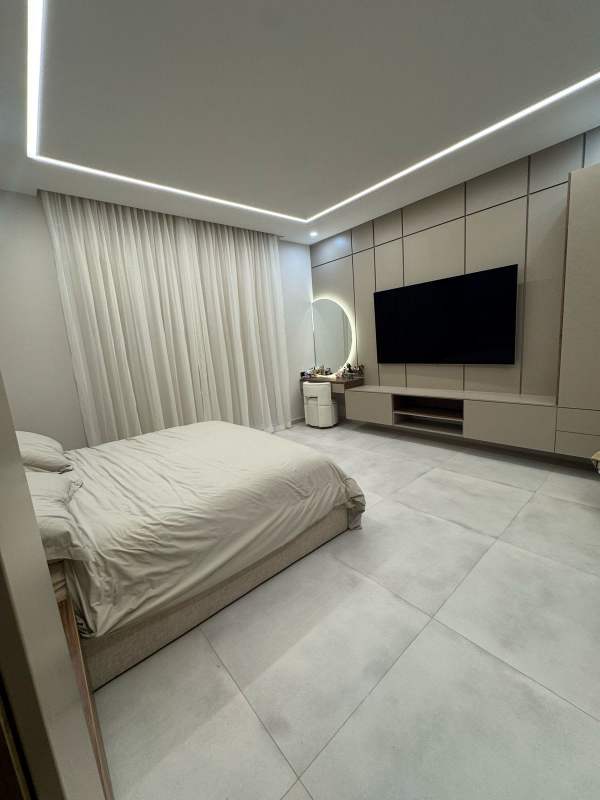 Bedroom with tile floors, built-in TV wall, neutral decor in Santa Maria Golf home Panama