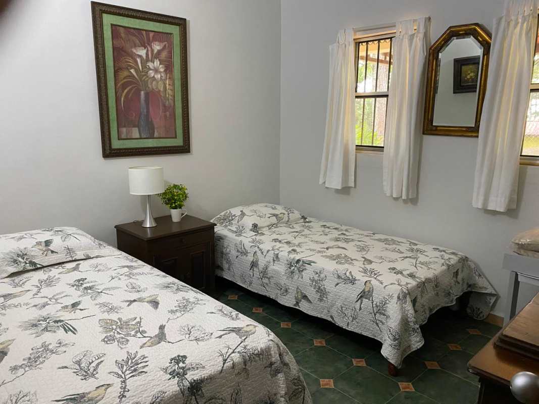 Traditional twin bedroom with nature-themed bedding in mountain house Cerro Azul Panama