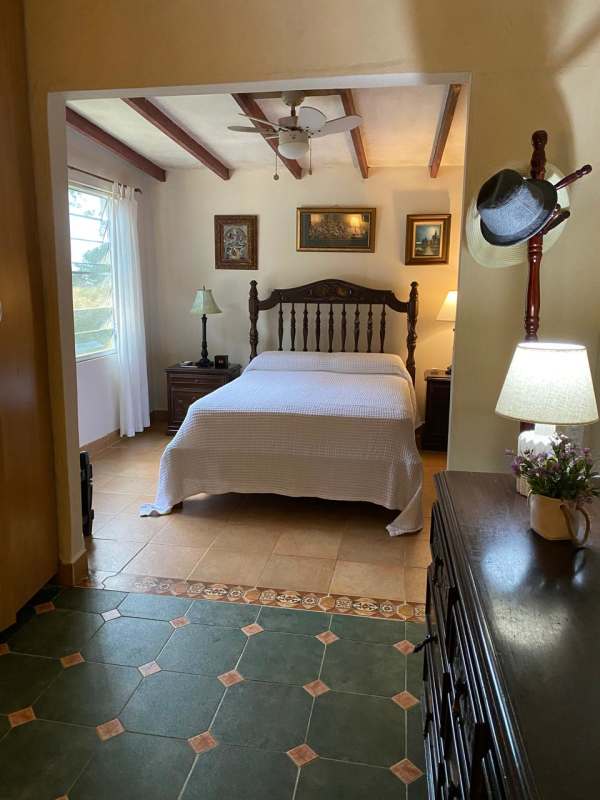 Bedroom with wooden furniture, exposed beams, tile flooring Cerro Azul mountain house