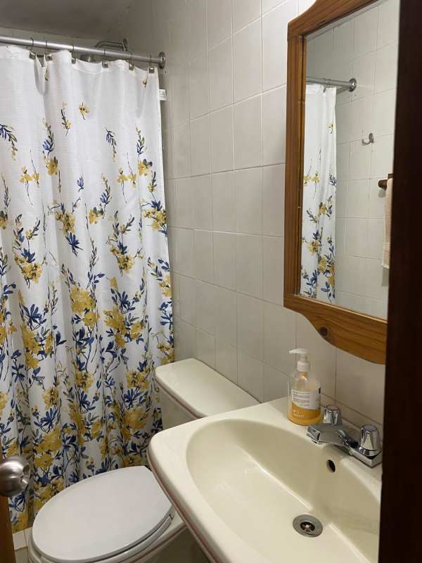 Small bathroom with floral shower curtain and wood framed mirror Cerro Azul Panama