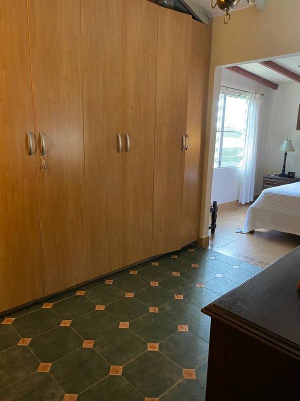 Bedroom with built-in wardrobe, ceiling fan, window in mountain home in Cerro Azul