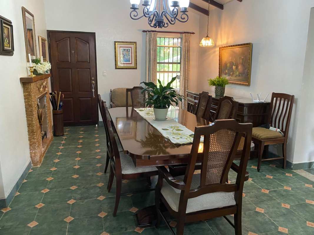 Dining room with chandelier, fireplace, exposed beams in mountain house Cerro Azul