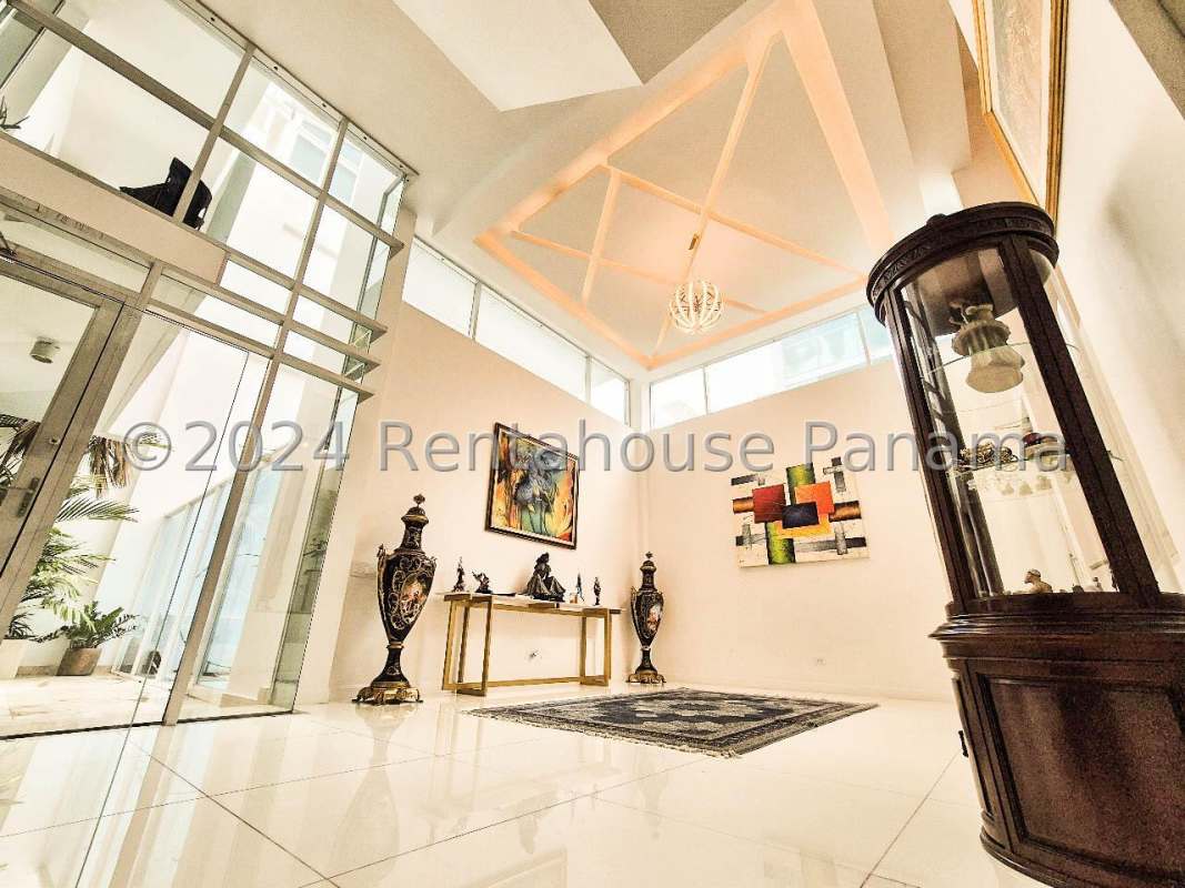 Double-height foyer with glass railing staircase floating stairs luxury rental PH Minimal Houses Panama