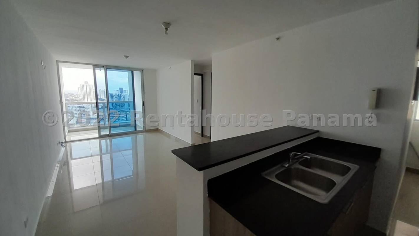 Modern apartment kitchen with granite counters and white cabinets in Coral Towers Panama