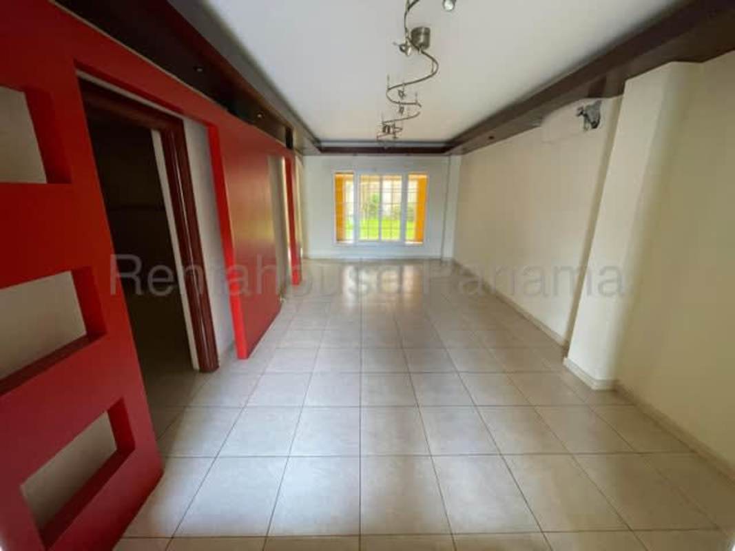 Formal living space with arch entry, bright windows, and tiled floors Ancón Panama