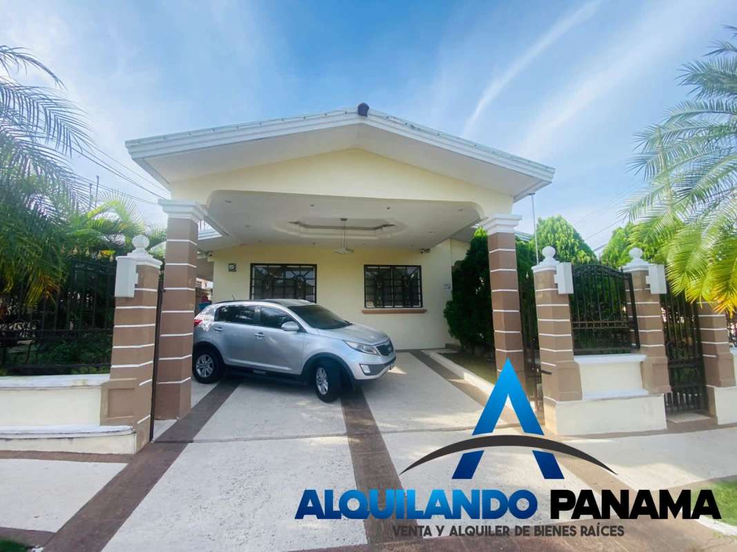 Front facade of the single story house with gated entrance, driveway, SUV, garden landscaping in Brisas del Golf Panama