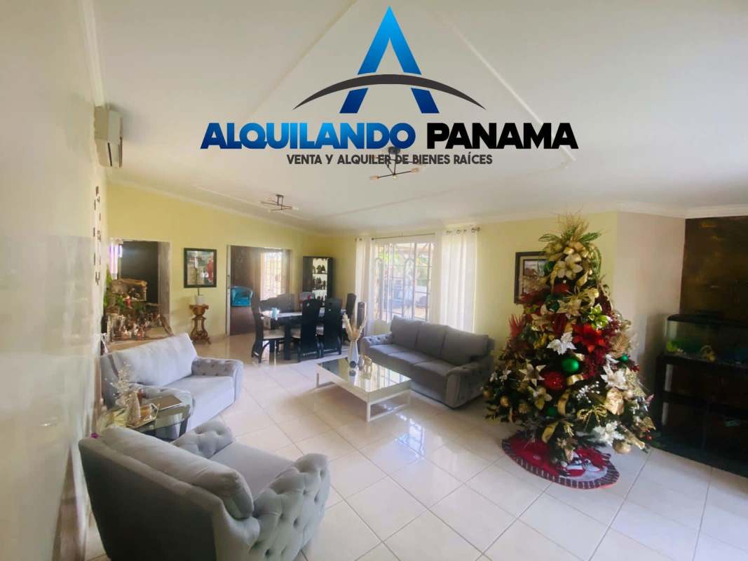 Living dining area with Christmas tree, large windows, grey furnishings in house at Brisas del Golf Panama